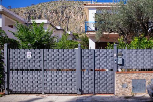 a fence in front of a building with a mountain in the background at Solemar Sicilia - Villa Mariù in Palermo