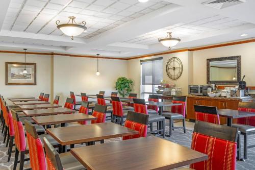 a restaurant with wooden tables and red chairs at Comfort Suites French Lick in French Lick