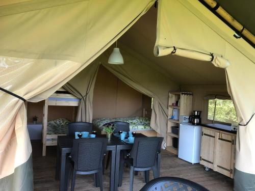 a tent with a table and chairs in it at Camping Emmen in Schoonebeek