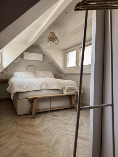 ein Schlafzimmer mit einem Bett und einem Tisch im Dachgeschoss in der Unterkunft C Studio Katwijk in Katwijk aan Zee