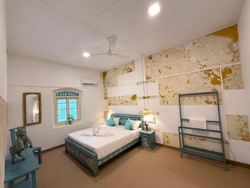 a bedroom with a bed and a mirror on the wall at Sudu Colonial House 1929 in Ambalangoda