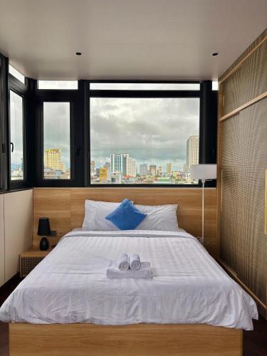a bedroom with a large bed with two towels on it at MAIA Hotel & Apartment Danang in Danang