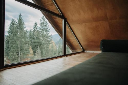a room with a large window looking out at the forest at Ліс Снів in Tatariv