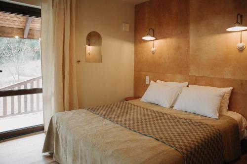 une chambre avec un lit avec des oreillers blancs et une fenêtre dans l'établissement Ліснів, à Tatariv