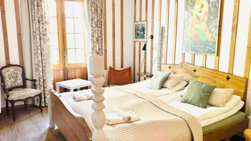 Un dormitorio con dos camas y una silla dentro. en Tallhöjden hotel & Nature Lodge, en Simlångsdalen