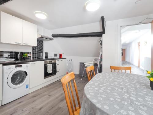 a kitchen and living room with a table and chairs at Room 1 At The Cwtch in Chepstow
