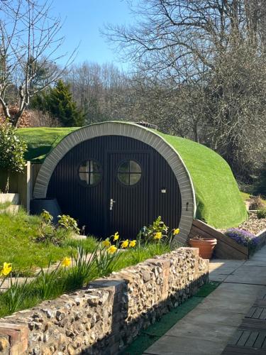 a circular house with a grass roof and a garden at Five Cottages in AONB and an Obbit House! in Canterbury