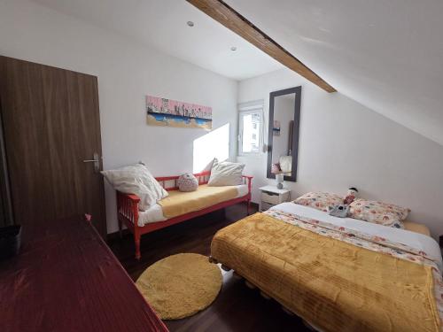 a bedroom with two beds and a chair in it at Appartement proche Strasbourg in Bischheim