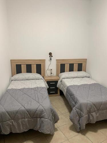 two beds sitting next to each other in a bedroom at Apartamento centro ciudad in Algeciras