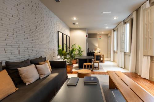 a living room with a couch and a brick wall at Colectia Stays Pau Claris in Barcelona