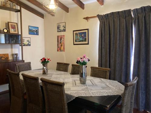 a dining room table with flowers in vases on it at Halibut Suite in Strand