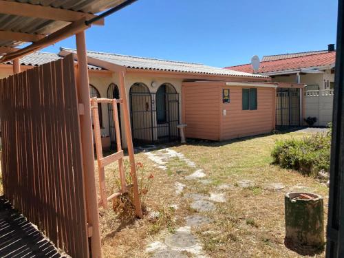 an outside view of a house with a fence at Halibut Suite in Strand