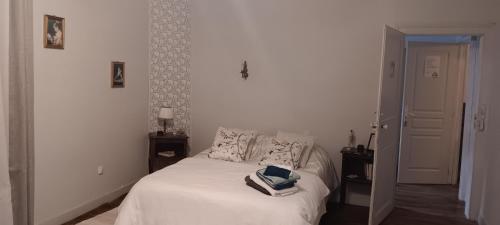 a bedroom with a bed with a book on it at Le domaine du Champ Han in Saint-Hilaire-du-Harcouët