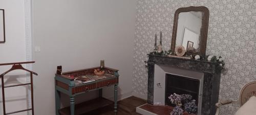 a living room with a fireplace and a mirror at Le domaine du Champ Han in Saint-Hilaire-du-Harcouët