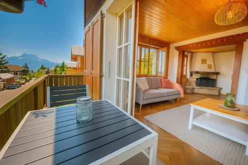 a porch of a house with a table and a couch at Chalet 6 personnes avec sauna in Leysin
