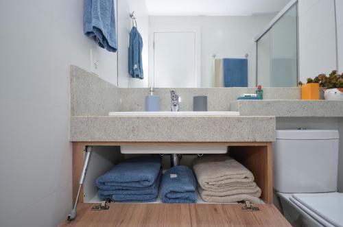 a bathroom with a sink and towels under it at Home Batel in Curitiba