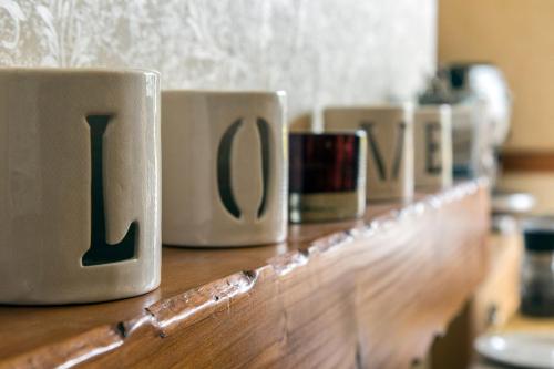 a row of coffee mugs sitting on a wooden counter at Laurel Bank Guest House in Keswick
