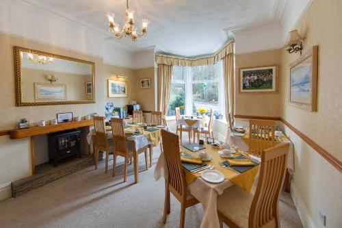a dining room with a table and chairs and a mirror at Laurel Bank Guest House in Keswick
