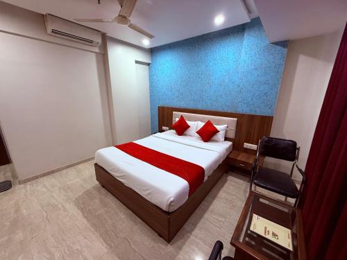 a bedroom with a large bed with red pillows at Hotel Arya Residency Rabale in Airoli