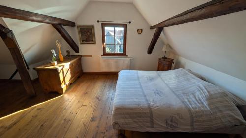 a attic bedroom with a bed and a window at Les Perles du Ried - Gîte 202 in Boofzheim