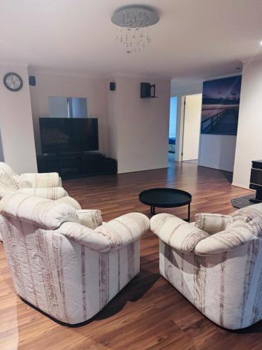 a living room with two couches and a table at 4 bedroom house in Berwick springs in Narre Warren South