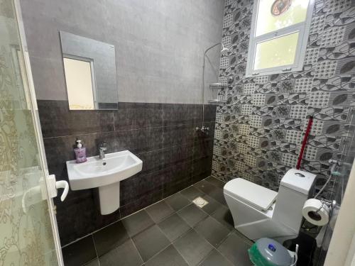 Un baño con un inodoro blanco y un lavabo. en Palm and wave, en Ţīwī