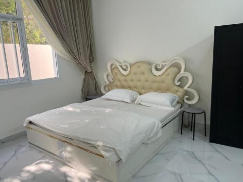 1 dormitorio con cama blanca y cabecero grande en Palm and wave, en Ţīwī