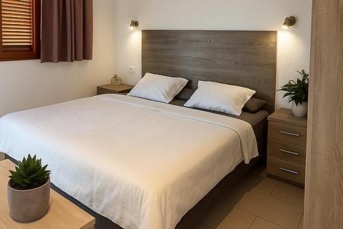 a bedroom with a large bed with a wooden headboard at BuzzStays: 1-Bed Bungalow, Garden, Near Yumbo & Beach in Maspalomas