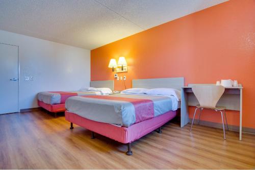 two beds in a room with orange walls at Motel 6 Eloy Arizona Casa Grande in Eloy