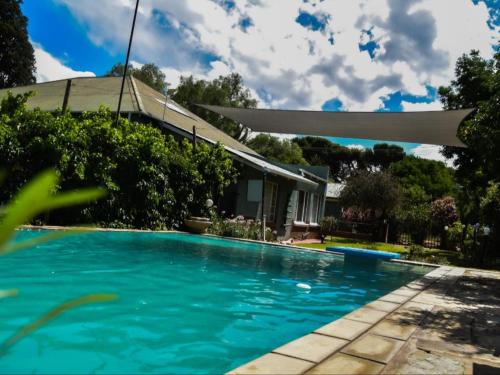 a swimming pool in front of a house at Anker Guesthouse in Philippolis