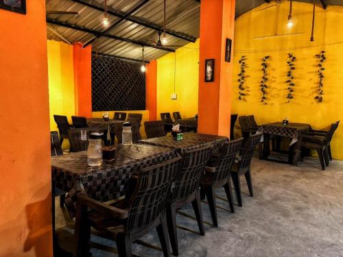 a restaurant with wooden tables and chairs in a room at The Tiger's Hill Retreat in Lagma