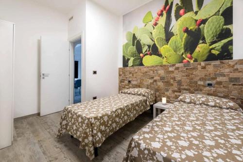 a room with two beds and a painting on the wall at Fichi d'India Appartamenti in San Pietro in Bevagna
