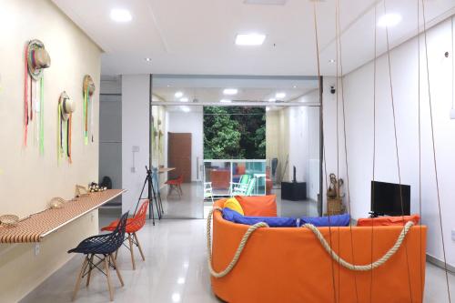 Una sala de estar con un sofá y sillas naranjas. en TACACÁ HOSTEL - Localização Privilegiada, en Belém