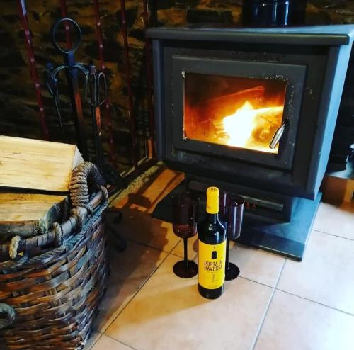 two bottles of wine next to a fireplace at Bela Vista Alqueve - traditional stone house and private pool in Arganil