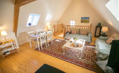 una sala de estar con un sofá y una mesa en Aux Roses et aux Poutres, en Le Tremblay-le-Vicomte