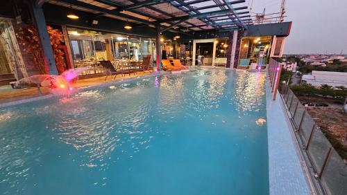 a swimming pool with an umbrella in the water at BlueTel Re'sidencE Bangkok IMPACT บลูเทล เรซิดองส์ กรุงเทพ อิมแพค in Nonthaburi