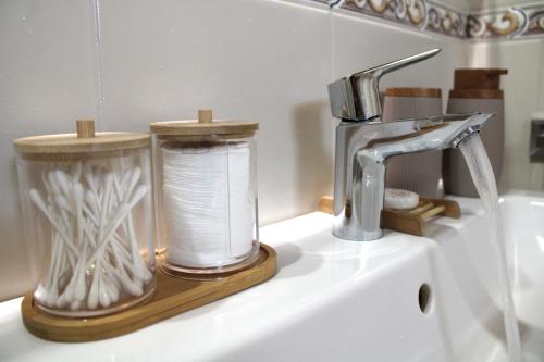 a bathroom sink with a faucet and a glass container of paper towels at Azores Panorama Lodge in Norte Pequeno