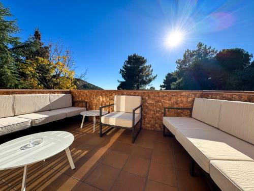 a patio with couches and a table and chairs at Casa Abetos in Collado Mediano
