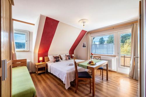 a hotel room with a bed and a table at Café Pension Pfaus Heidburg in Mühlenbach
