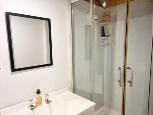 une salle de bain avec un lavabo blanc et une douche dans l'établissement Kiwi Beach Bach - Hot Tub - 2 bed, à Whangapoua