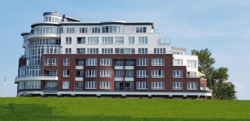 a large building sitting on top of a green field at Se 06 Haus Seeterrassen in Cuxhaven