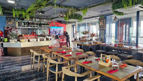 a restaurant with wooden tables and chairs and a counter at BlueTel Re'sidencE Bangkok IMPACT บลูเทล เรซิดองส์ กรุงเทพ อิมแพค in Nonthaburi