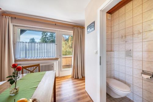 a bathroom with a table and a toilet and a window at Café Pension Pfaus Heidburg in Mühlenbach