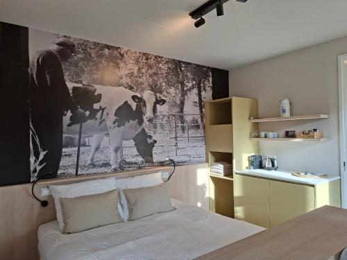 a bedroom with a black and white picture of a cow at aan de Dreef in Zundert