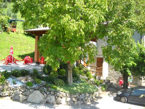 a tree in front of a house with a car at Agriturismo Cascina Lert in Marone