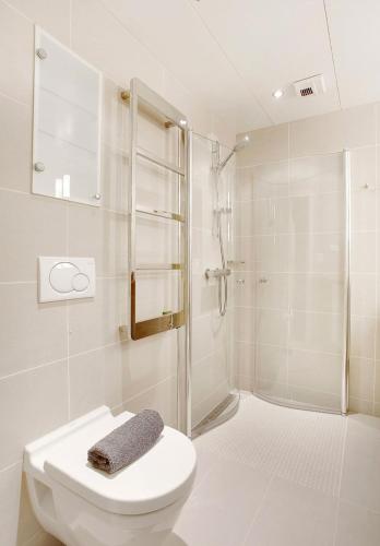 a white bathroom with a shower and a toilet at Seafront Luxury In Oslo in Oslo