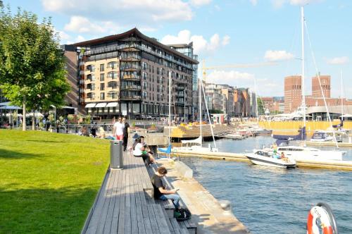a group of people sitting on a dock near a marina at Seafront Luxury In Oslo in Oslo