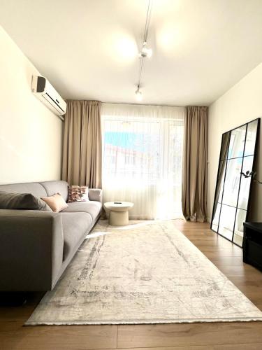 a living room with a couch and a large window at IN&P Apartment - top location in Veliko Tŭrnovo