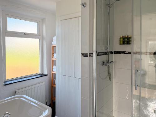 ein Badezimmer mit Dusche und Waschbecken in der Unterkunft Yellow Cottage, Doolin in Knockfin Cross Roads