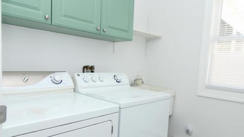 een witte wasruimte met een wasmachine en droger bij Bay Beach Bungalow in Town Bank